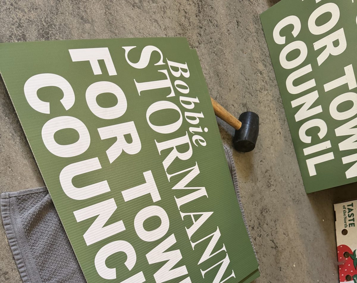 Several Bobbie Stormann for Town Council yard signs ready to install